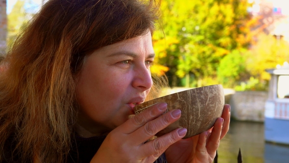 Woman Drinking Coconut Beer From Bowl in Belgium Street Cafe