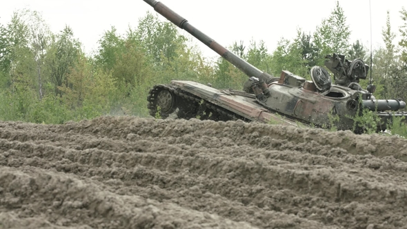 Military Tank in Movement on a Dirt Ground Terrain