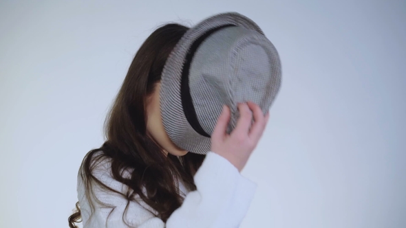 Pretty Young Girl Plays with Hat and Wears on Head with Cute Smile