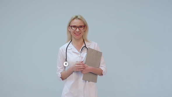 Female Doctor with White Coat and Stethoscope Smiling Looking Into Camera
