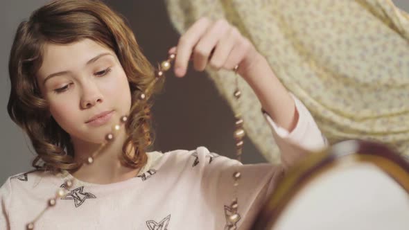 Young Lady with Interest Examining and Putting on Mothers Beads Growing Up