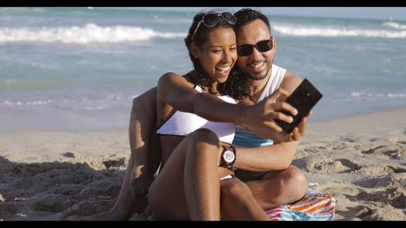Happy Diverse Couple Taking Selfie on Beach