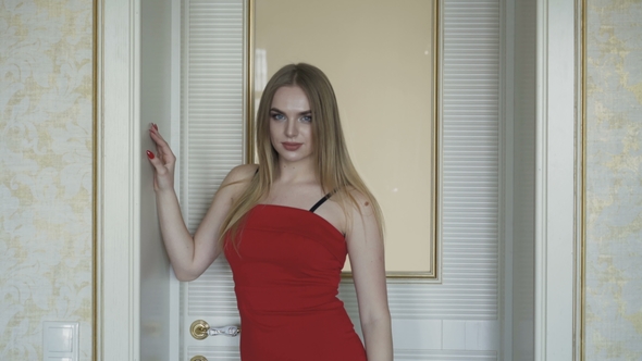 Seductive Blue-eyed Blonde in Red Dress Posing at Camera