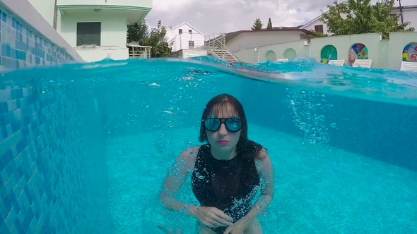 Woman with Long Hair Dives Into the Pool