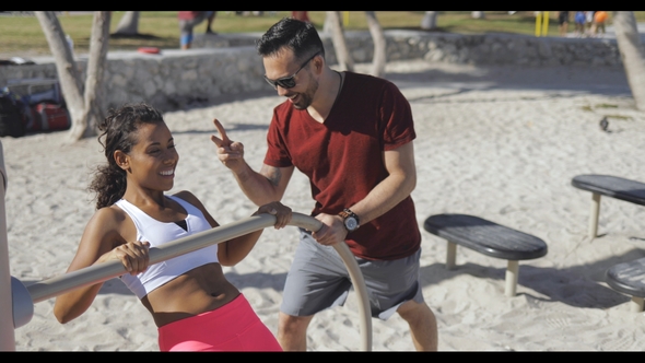 Man Training Woman on Beach