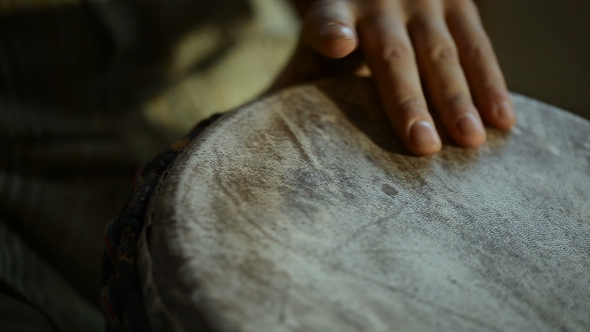 Man's Hands Drumming Out a Beat on an African Skin-covered Hand Drum.