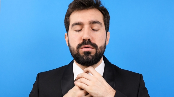 Tired and Stressed Businessman Untying His Tie on Blue Background