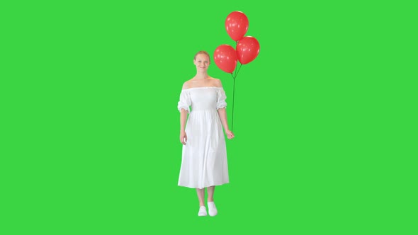 Smiling Young Woman Wearing White Dress with Balloons on a Green Screen Chroma Key