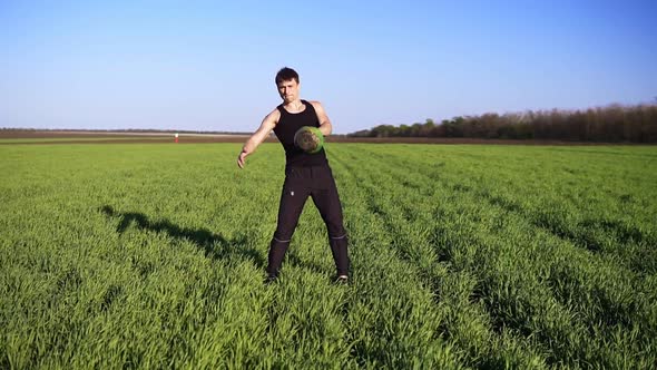 Front View of Muscular Young Man Engaged in Lifting in the Open Area