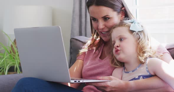 Caucasian mother and daughter having fun using laptop