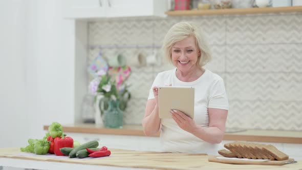 Loving Senior Old Woman Doing Video Call on Tablet in Kitchen