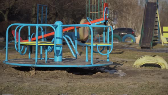 Empty Swing is Spinning on the Playground in the Yard