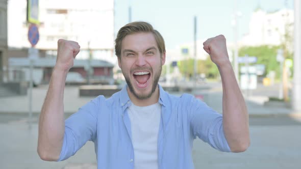 Portrait of Excited Man Celebrating Success Outdoor