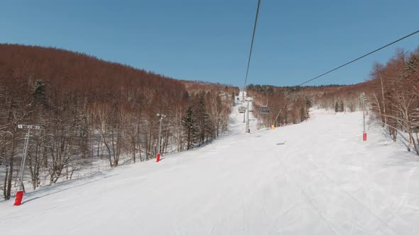 Riding on Ski Lift Above the Slopes in the Morning