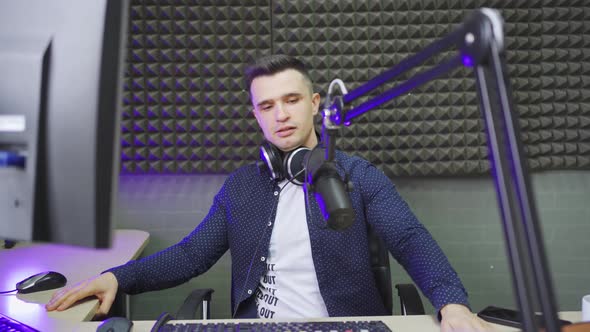 a Male Radio Host Conducts a Live Broadcast in a Professional Radio Studio