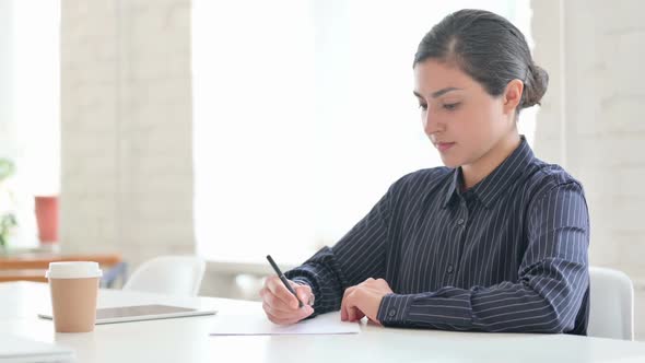 Young Indian Woman Writing on Paper
