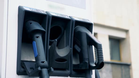 Male Hand Is Pulling Out an Electric Refueling Nozzle To Recharge an Electrocar