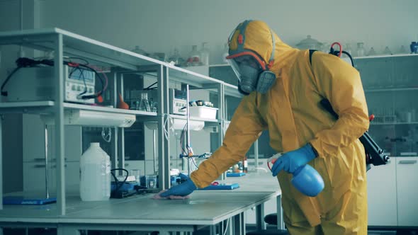 Man Cleans Desks in Room, Using Antiseptic To Kill Virus