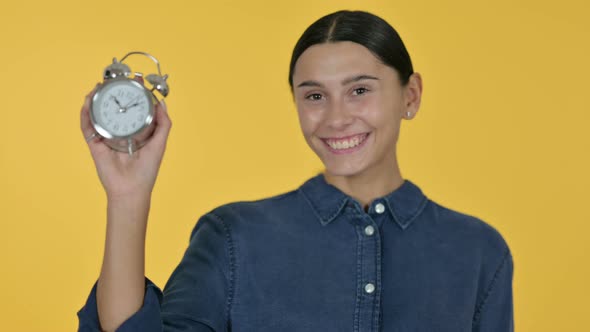 Latin Woman Holding a Clock, Yellow Background 