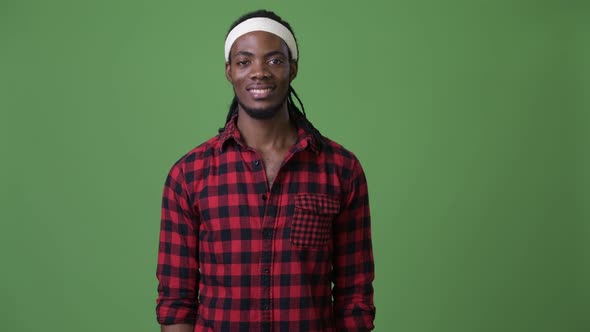 Young Handsome African Man with Dreadlocks Against Green Background