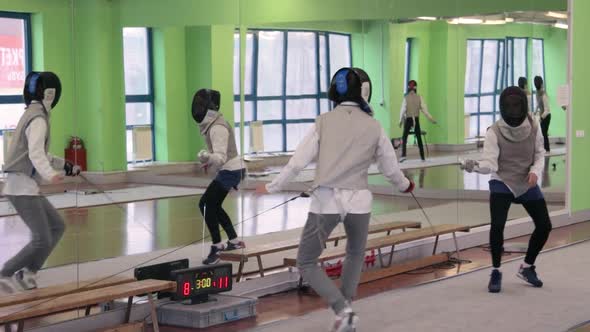 Teenagers practicing fencing at a fencing school