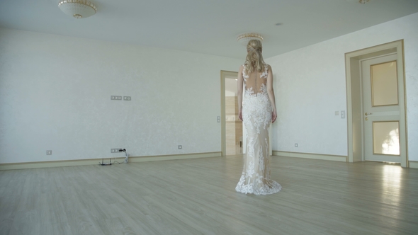 Gorgeous Bride Walks in Room and Poses at Camera