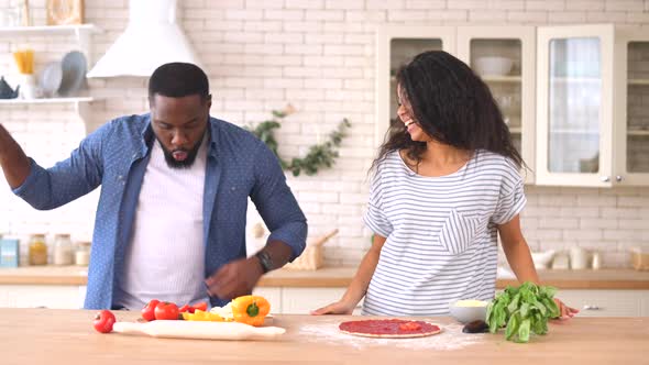 Happy Multiracial Couple Preparing Pizza Together at Home