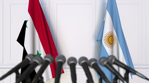 Flags of Syria and Argentina at International Press Conference alt