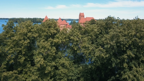 Aerial Drone Shot of Trakai Castle in Lithuania. Flight Over Trees. Beautiful Castle on the Lakes