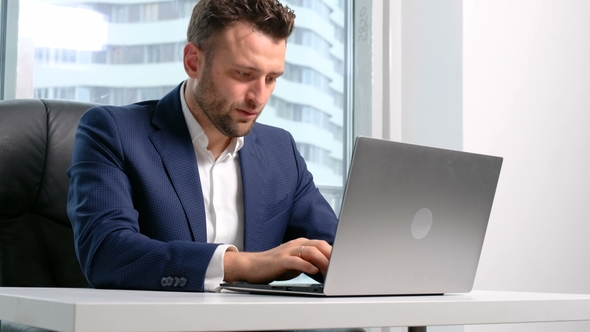 Businessman in Formal Wear Using Laptop in Office