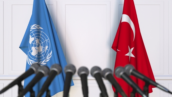 Flags of the United Nations and Turkey at International Press Conference alt