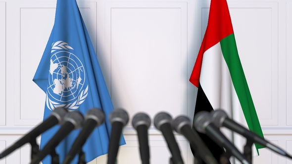 Flags of the United Nations and the UAE at International Press Conference alt