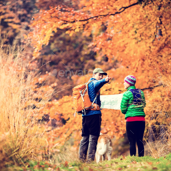 est with akita dog. Young couple looking at map and planning trip or get lost, vintage retro instagram style photo