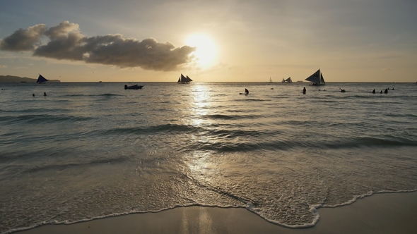 Foam of Coastal Waves in the Rays of the Sunset on the Island of Boracay