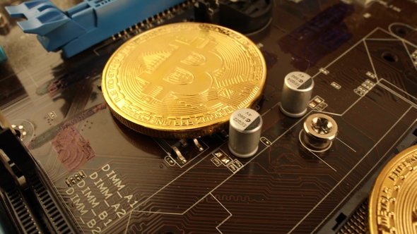 Gold Bit Coin BTC Coins on the Motherboard. Bitcoin Is a Worldwide Cryptocurrency