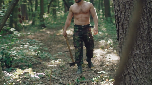 Portrait of Handsome Bearded Man with Ax in the Forest