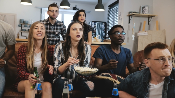 Cross-cultural Group Watch Sports Game on TV. Passionate Supporters Celebrate Goal with Drinks.   .