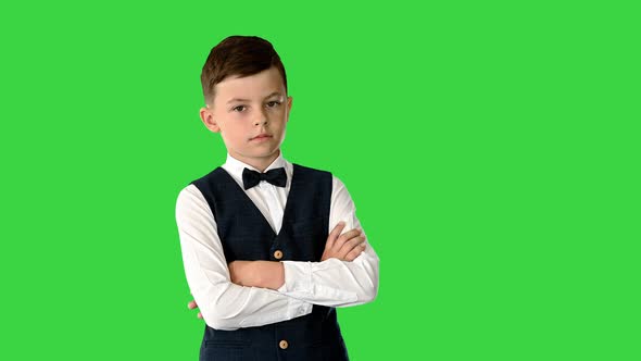 Confident Young Boy in Bow Tie and Vest Crossing His Arms and Putting Hands in His Pockets While