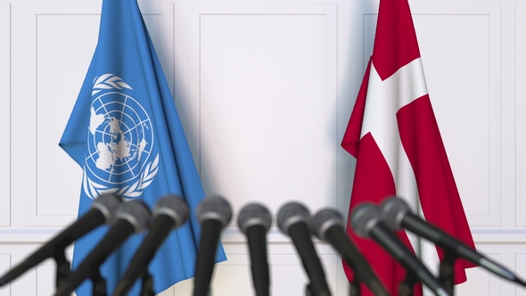 Flags of the United Nations and Denmark at International Press Conference alt