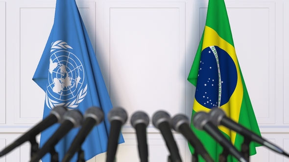 Flags of the United Nations and Brazil at International Press Conference alt