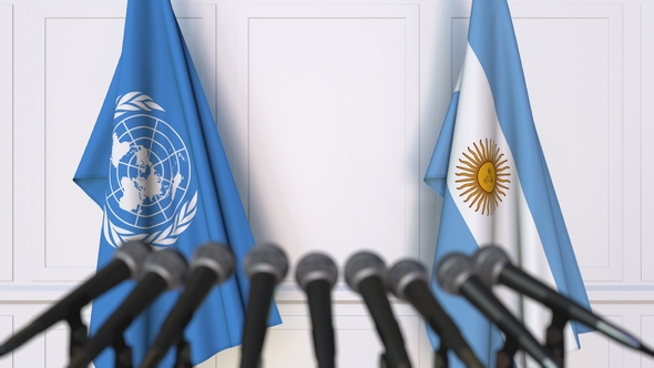 Flags of the United Nations and Argentina at International Press Conference alt