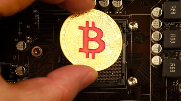 Gold Bit Coin BTC Coins on the Motherboard. Bitcoin Is a Worldwide Cryptocurrency