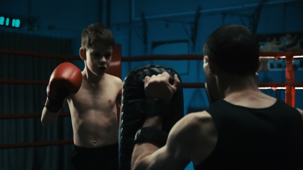 Man Training with Boy on Boxing Ring