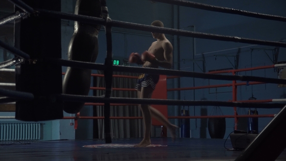 Man Training with Punching Bag in Gym