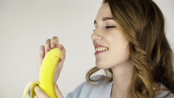 Beautiful Young Girl Peeling a Tasty Banana and Eating It