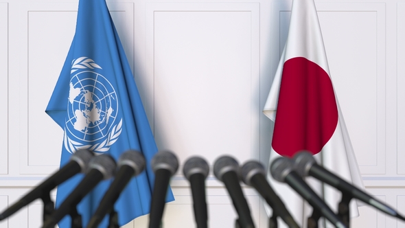 Flags of the United Nations and Japan at International Press Conference alt