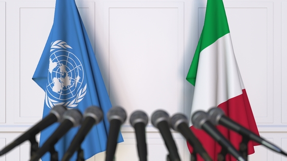 Flags of the United Nations and Italy at International Press Conference alt