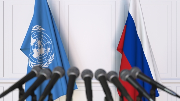 Flags of the United Nations and Russia at International Press Conference alt