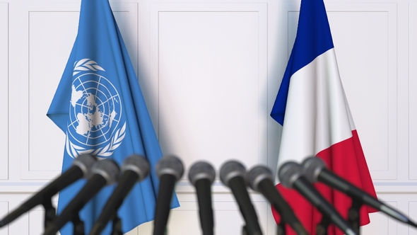 Flags of the United Nations and France at International Press Conference alt