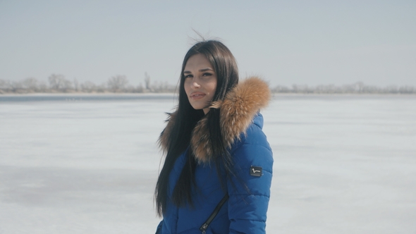 Portrait of Young Beautiful Brunette Woman in Winter on a Snow Background